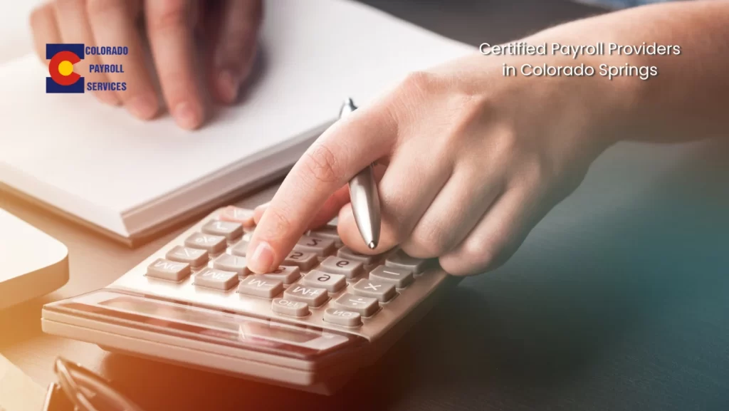Business professional calculating payroll with certified payroll providers in Colorado Springs